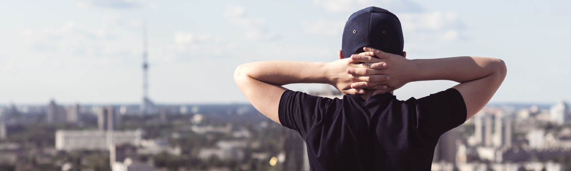 Junge Person blickt auf die Skyline einer Stadt