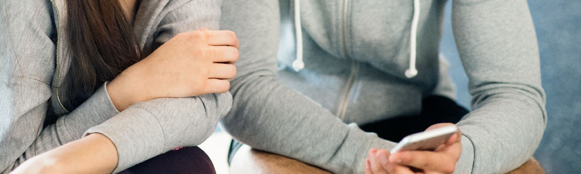 Zwei Jugendliche schauen auf ein Smartphone